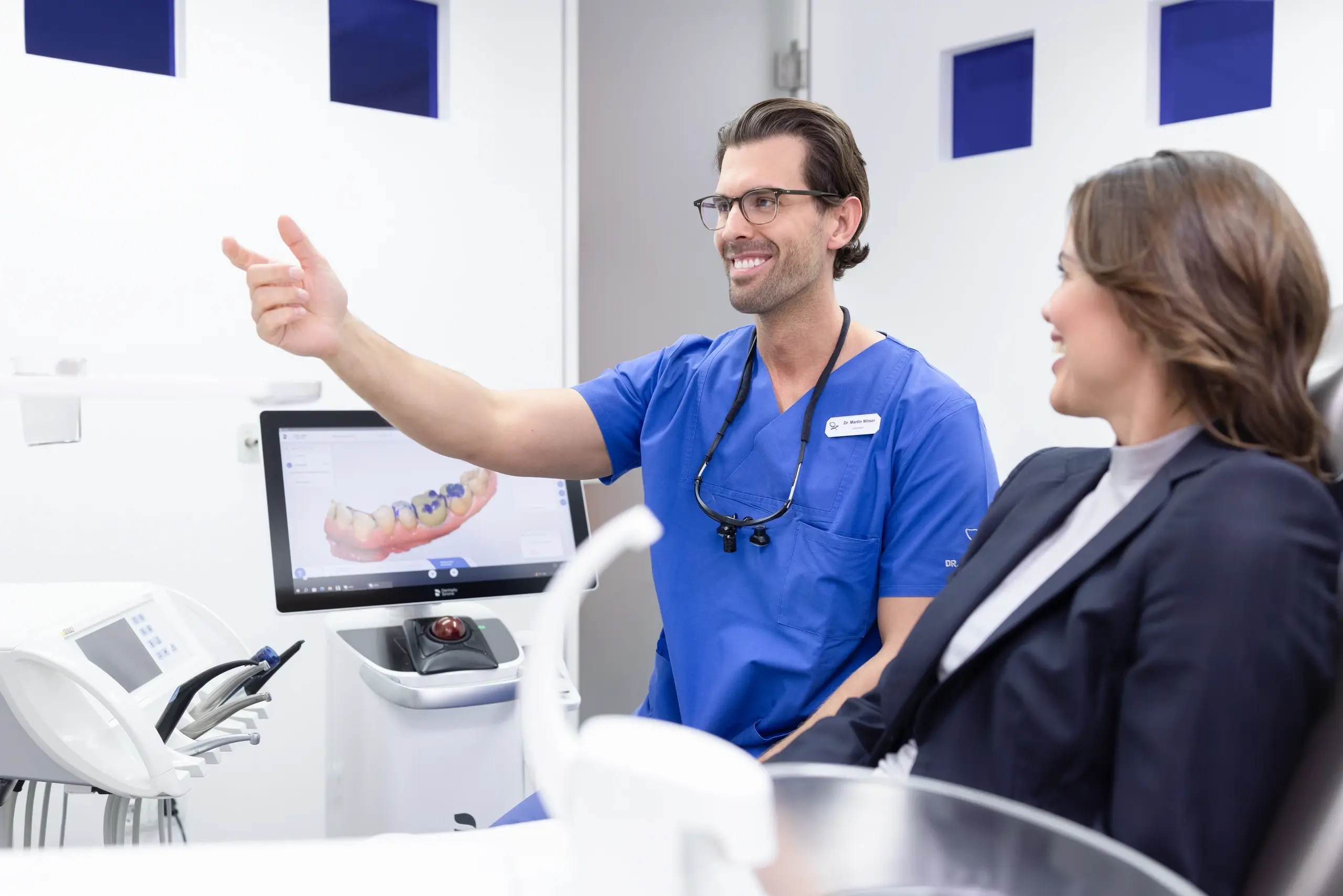 Zahnarzt erklärt einer Patientin die Aufnahmen am Bildschirm