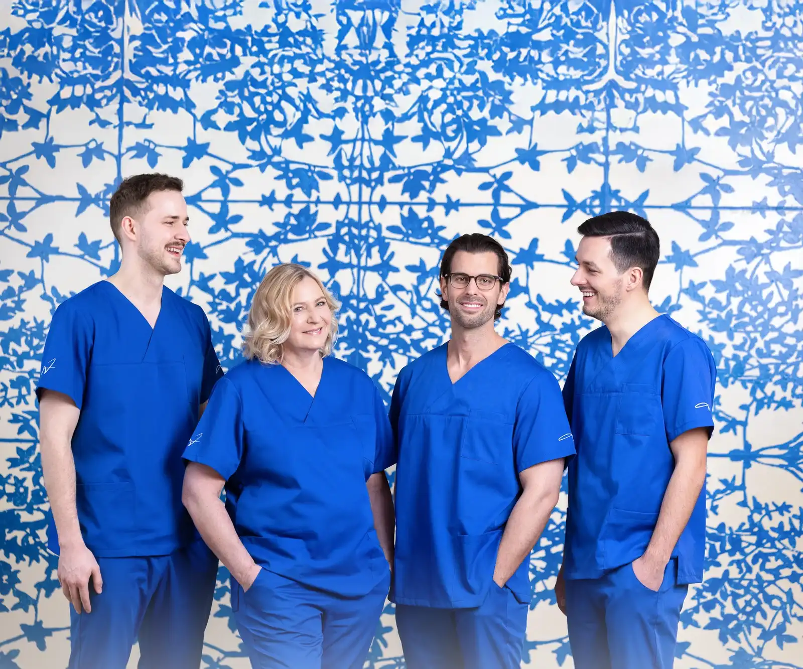 Das Ärzteteam des Dr. Jung MVZ vor der blauen Ornamentwand